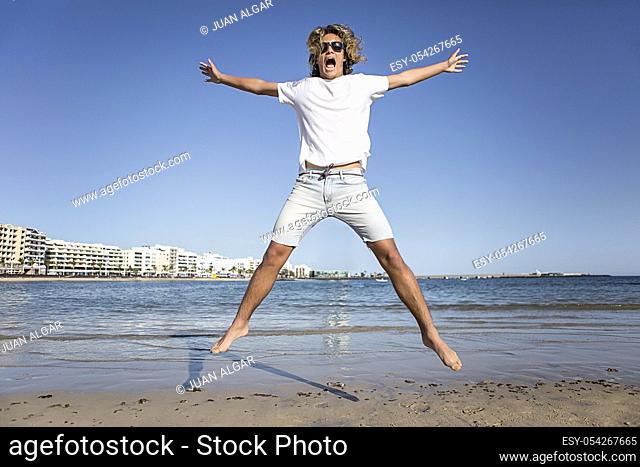 Young man jumping near the water