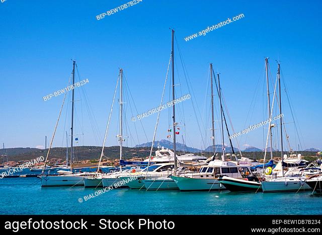 Golfo Aranci, Sardinia / Italy - 2019/07/16: Panoramic view of Golfo Aranci yacht port - Marina di Golfo Aranci - with seashore park boulevard at the Tyrrhenian...