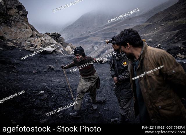 12 November 2022, Afghanistan, Chinarak: Two men try to calm down a boy who works in the informal coal mines in Chinarak in Afghanistan's Baghlan Province who...