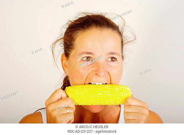 Woman eating corncob, corn