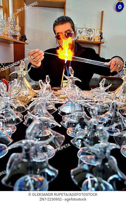 Glassblower makes glass figures of whirling dervishes in Mevlana Cultural Center, Konya, Turkey