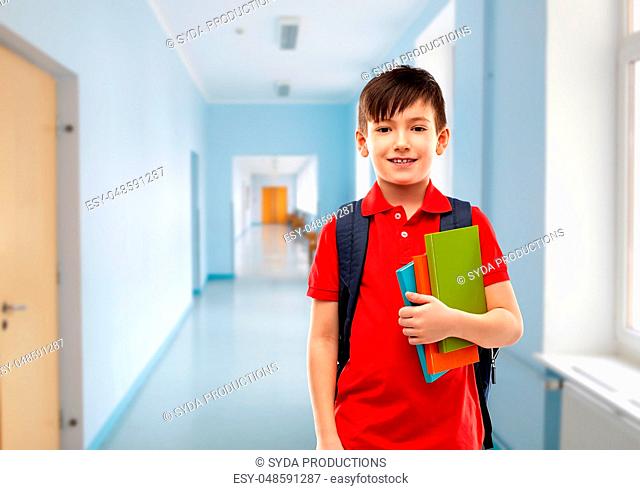 smiling student boy with books and school bag