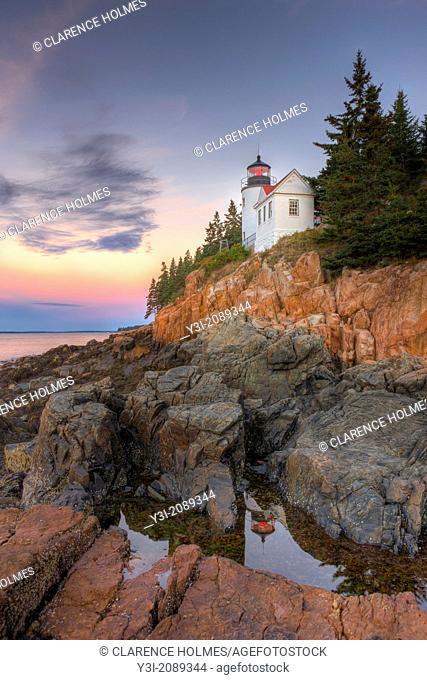 Bass Harbor Head Lighthouse is reflected in a tidal pool shortly before sunrise as it overlooks the entrance to Bass Harbor and Blue Hill Bay in Tremont, Maine