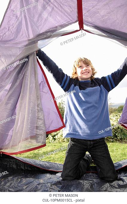 Boy climbing into tent