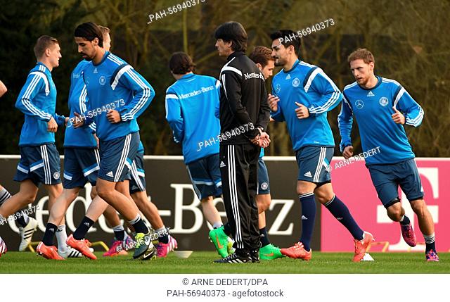 German national soccer team's head coach Joachim Loew (C) watches his team excercising during the team's final training session in Frankfurt Main, Germany