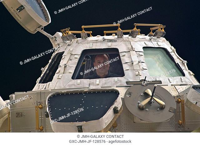 Backdropped by the blackness of space, NASA astronaut Ron Garan, Expedition 28 flight engineer, is pictured in a window of the Cupola of the International Space...