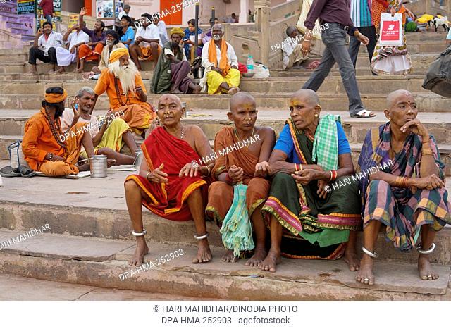 Shaved head woman sitting on ghat, varanasi, uttar pradesh, india, asia