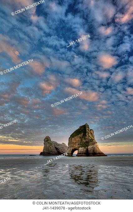 Archway Islands, sunrise lights up high clouds, Wharariki beach, near Collingwood, Golden Bay, New Zealand