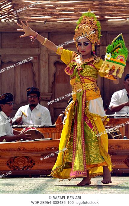 Balinese woman dancing Tari Pendet Dance. Pendet is a traditional dance from Bali, Indonesia, in which floral offerings are made to purify the temple as a...