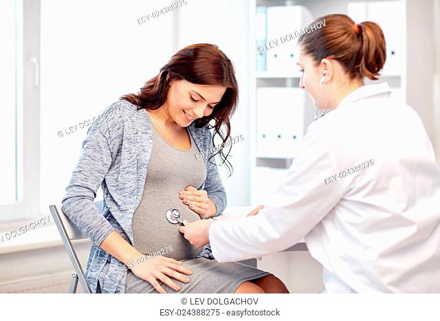 pregnancy, gynecology, medicine, health care and people concept - gynecologist doctor with stethoscope listening to pregnant woman baby heartbeat at hospital