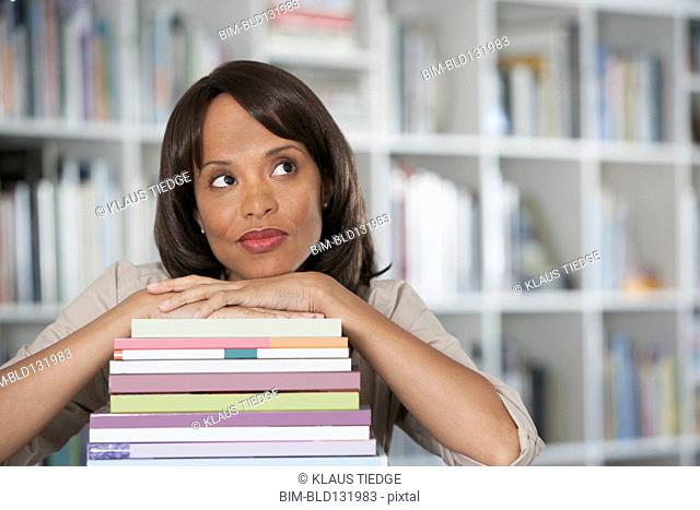 Woman leaning on stack of books