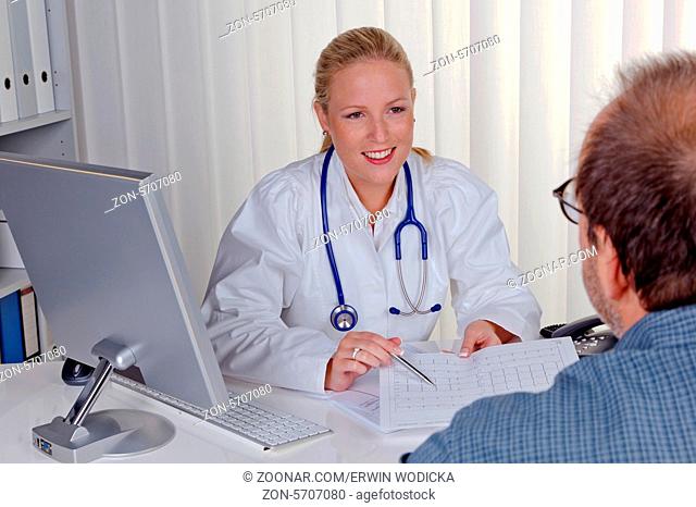 Eine junge Ärztin mit Stethoskop in ihrer Arztpraxis. Im Gespräch mit einem Patienten
