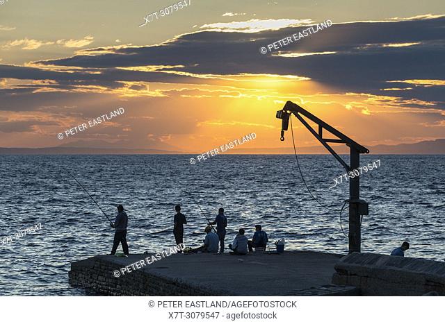 Workers at Xenophontos Monastery fishing on the quay. Athos peninsula, Chalkidiki, Macedonia, Northern Greece