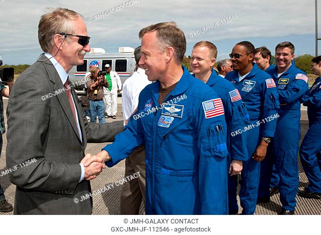 Bill Gerstenmaier, associate administrator for Space Operations, greets the STS-133 crew members as they exit the crew transport vehicle after landing at NASA's...