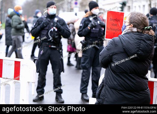 22 January 2022, North Rhine-Westphalia, Duesseldorf: A counter-demonstrator holds a sign reading ""Vaccinate not scold!""