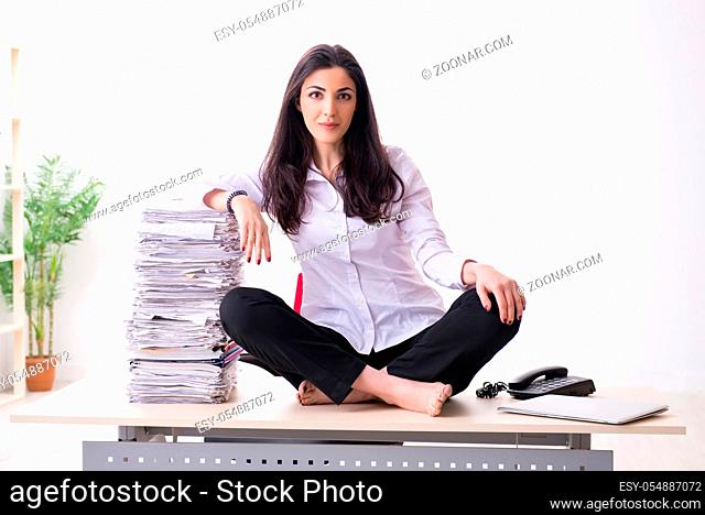 Young female employee doing exercises in the office