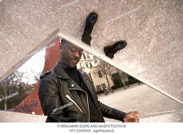 young African man looking down at his feet, in Munich, Germany