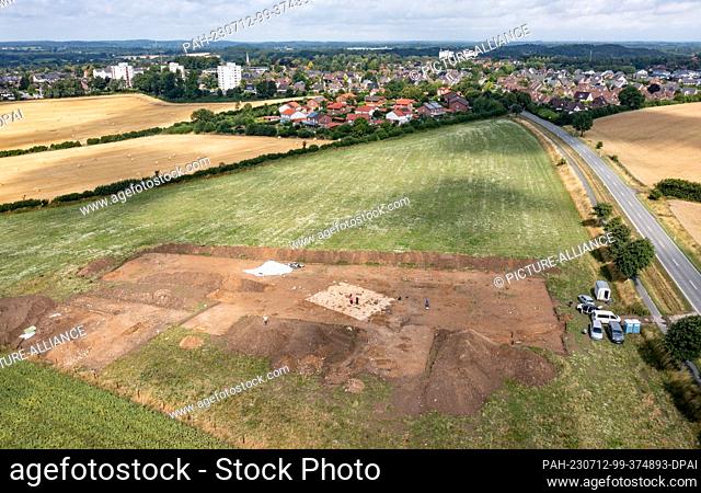 12 July 2023, Schleswig-Holstein, Flintbek: Excavation workers are working on settlement traces from the 4th to 5th century BC from the Migration Period in the...