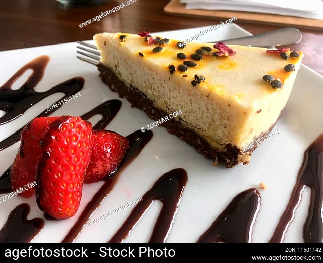 AIP Autoimmune Paleo or healthy eating choices. Slice of cashew milk cheesecake on a plate in a wellness organic cafe. Gluten free dairy free