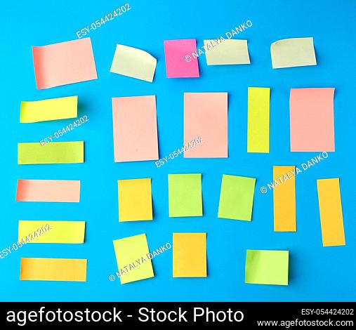 multicolored paper stickers of different shapes on a blue background, backdrop for the designer