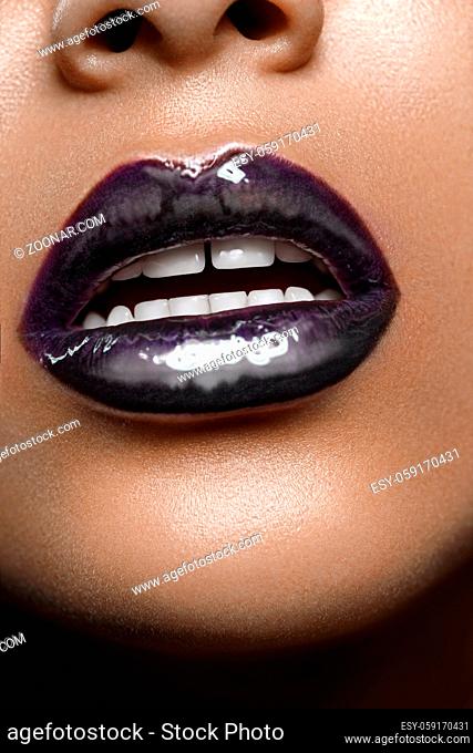 closeup shot of full sexy woman lips with black glossy lipstick. copyspace