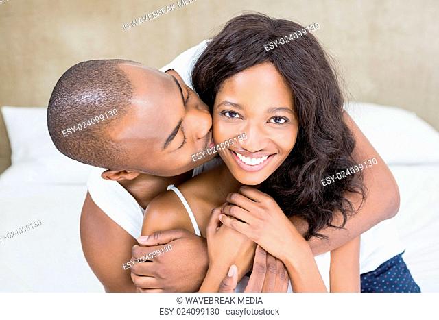 Young man kissing woman on her cheek