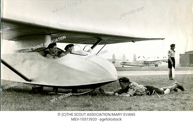 Two Scouts sit in a Slingsby T.21 while another Scout connects it to a cable prior to launch at the first Air Scout Gliding Course at Lasham