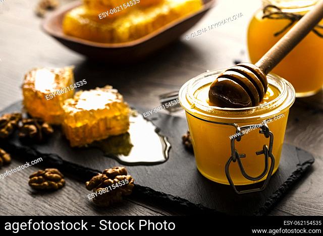 Honeycomb on slate tray with honey and nuts on kitchen table