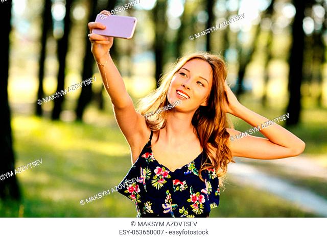 Happy girl makes selfie on a smartphone