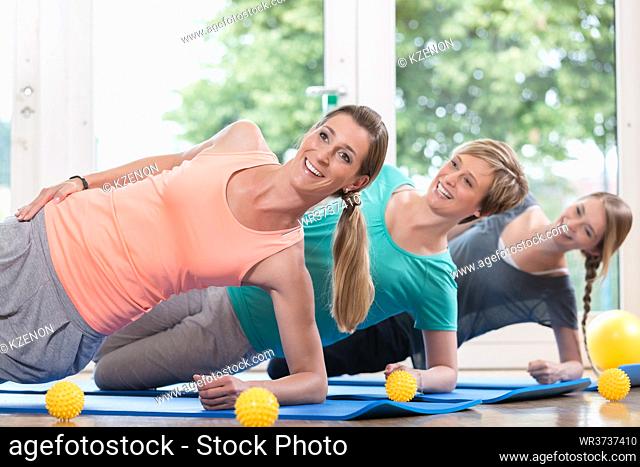Women doing exercises for pelvis floor in postnatal regression course