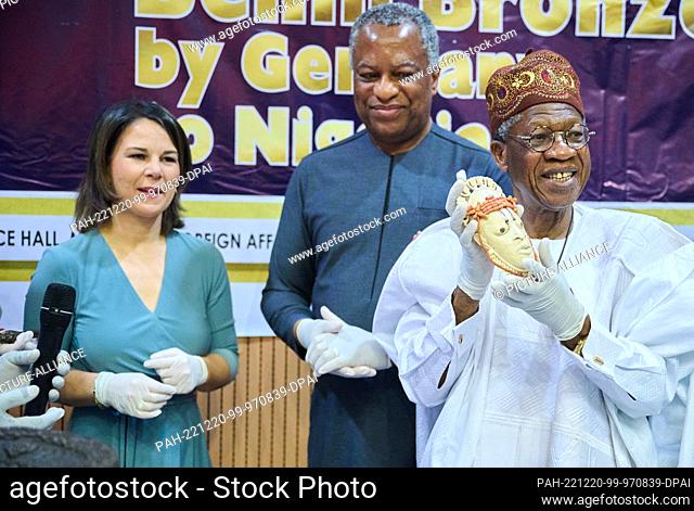 20 December 2022, Nigeria, Abuja: Alhaji Lai Mohammed (r), Minister of Information and Culture in Nigeria, holds the miniature ivory mask from Stuttgart
