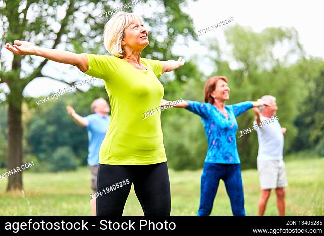 Vitale Senioren in einem Yoga oder Gymnastik Kurs mit gestreckten Armen