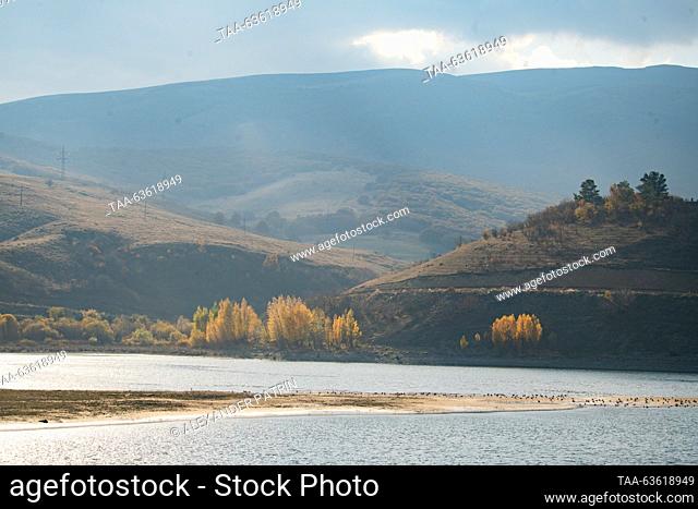 ARMENIA, KOTAYK PROVINCE - OCTOBER 21, 2023: A view of a reservoir on the Hrazdan River amid mountains at sunset. The reservoir is part of the Sevan–Hrazdan...