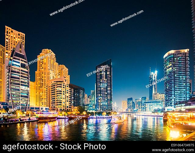Night view of skyscraper of residential district in Dubai Marina And Tourist Boat, Sightseeing Boat Sailing On Dubai Marina