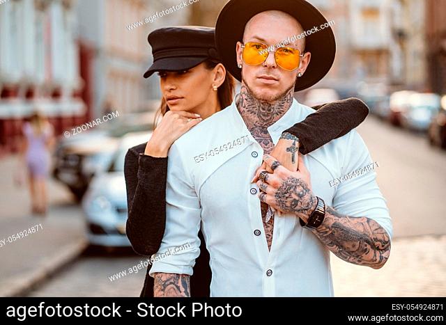 A young, sexy couple of lovers pose for a camera on the streets of the city