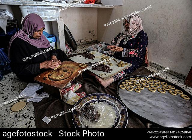 28 April 2022, Palestinian Territories, Rafah: Palestinian women prepare traditional biscuits ahead of the Eid al-Fitr festivities
