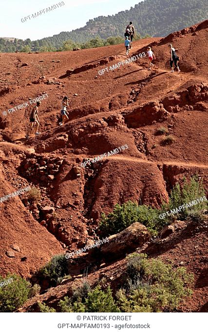 HIKING ON THE RED EARTH HILLS OF THE DJEBEL KLELOUT NEAR THE BERBER VILLAGE OF OUTGHAL, AL HAOUZ, MOROCCO