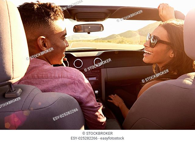 Couple On Road Trip Driving In Convertible Car