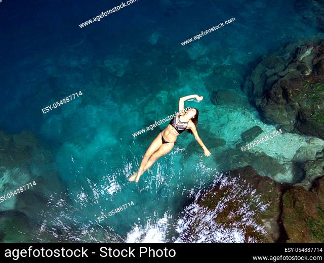 A beautiful hispanic brunette model enjoying a swim in a local cenote near Yucatan, Mexico
