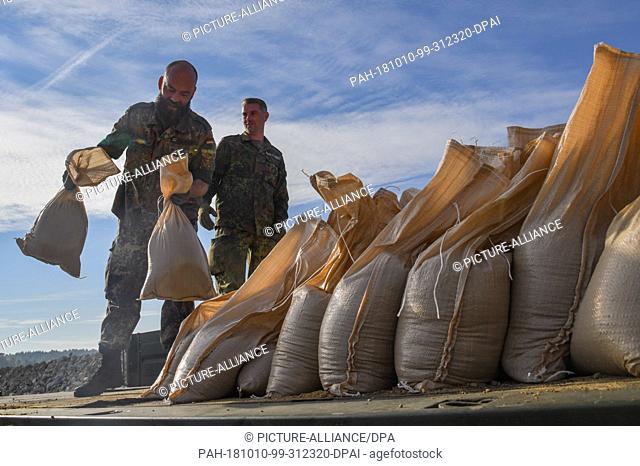 10 October 2018, Brandenburg, Guben: The loading of sandbags is being rehearsed by Bundeswehr soldiers during the disaster control exercise ""Flood 2018"" not...