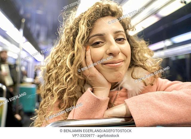 content woman in public transport metro train, in Paris, France