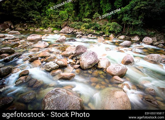 Water of the Mossman River flows over ancient rocks and boulders in Mossman Gorge, Queensland, Australia