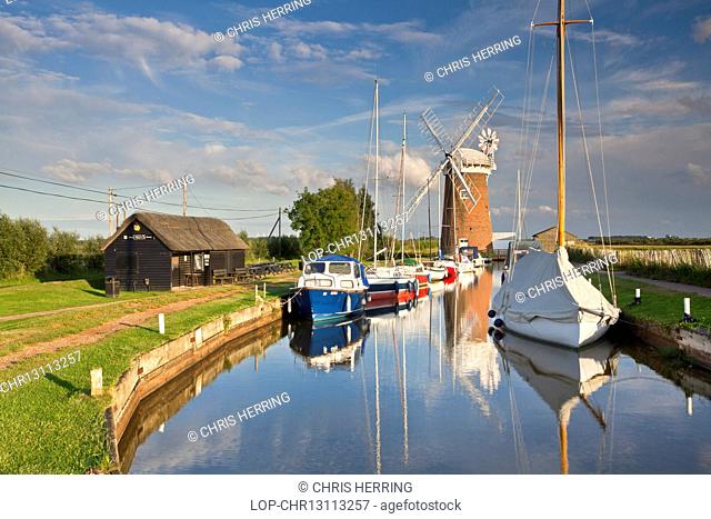 England, Norfolk, Horsey. Horsey Drainage Mill and boats on a summer evening on the Norfolk Broads