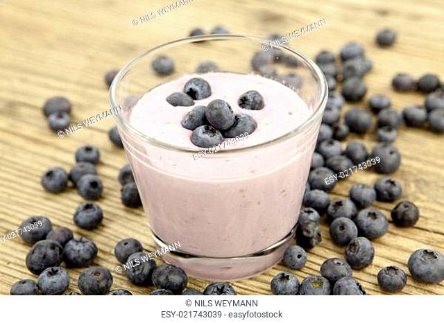 Frischer leckerer Joghurt mit Heidelbeeren und Blaubeeren isolie