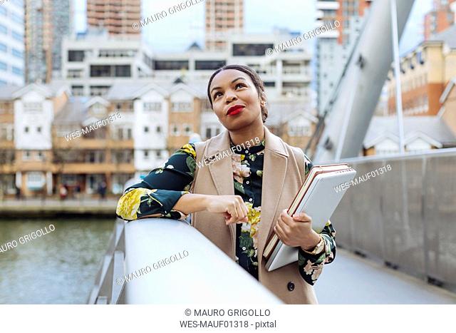 UK, London, portrait of fashionable businesswoman leaning on railing of bridge