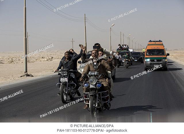 03 November 2018, Egypt, New Minya: People ride their motorcycles as they head to the Coptic graves during the funeral of the victims who were killed during a...