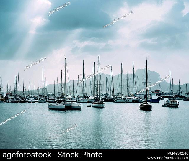 Sailboats and pleasure boats in the porto grande bay of the historic city Mindelo. Clodscape with Sunrays