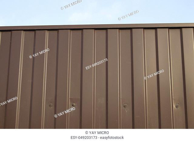 Modern aluminum fence of corrugated panel corrugated metal siding brown