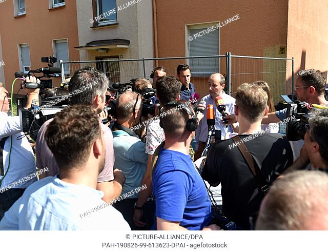 26 August 2019, North Rhine-Westphalia, Herne: Christoph Hüsken, press spokesman for the city of Herne, speaks to journalists in front of an apartment building