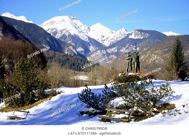 Julian alps. Mountains. Trek. Climb. Statue of four climbers. At start of route. Snow on ground. On mountain peaks